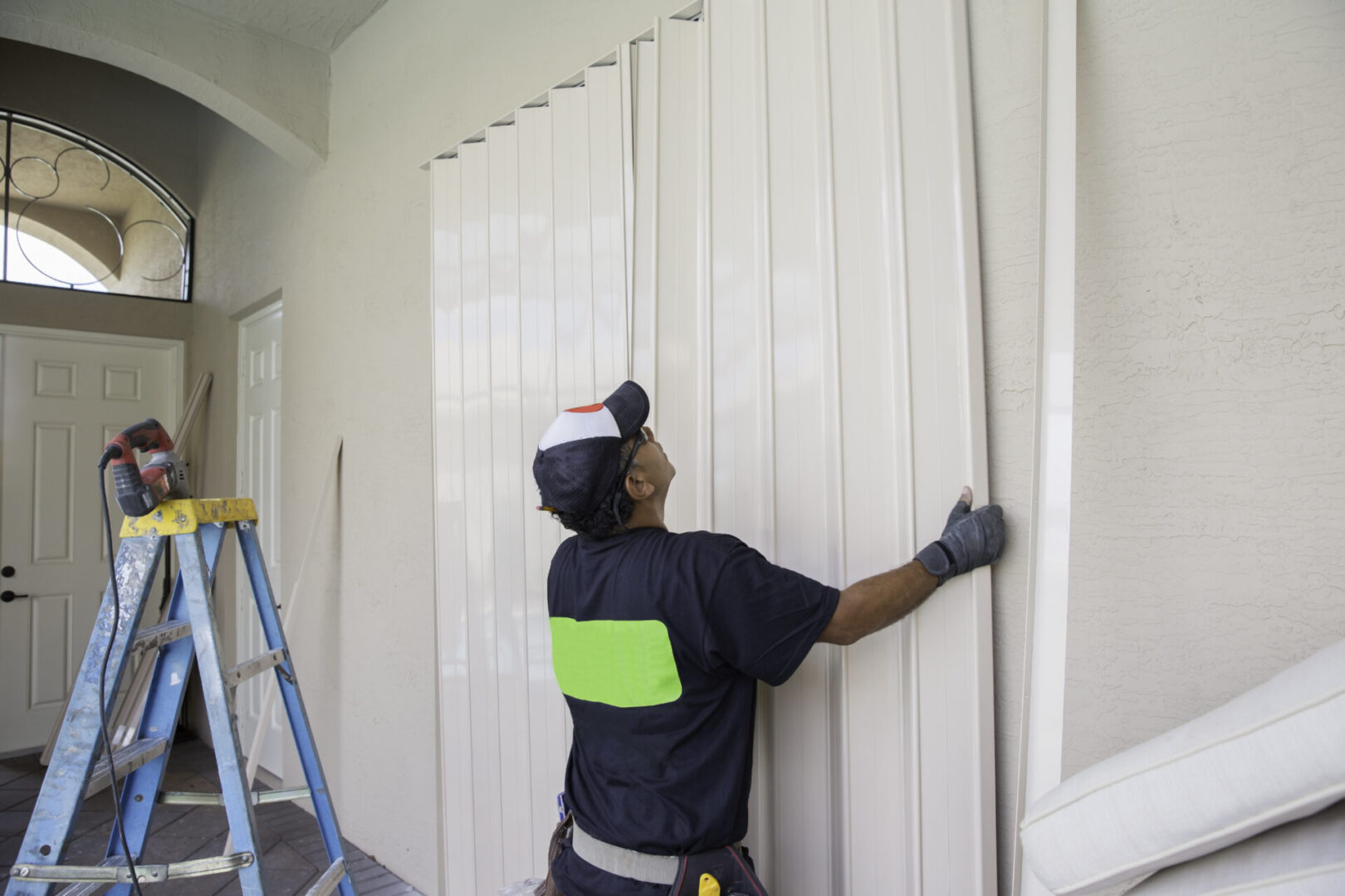 Contractor installing hurricane shutters.  rr